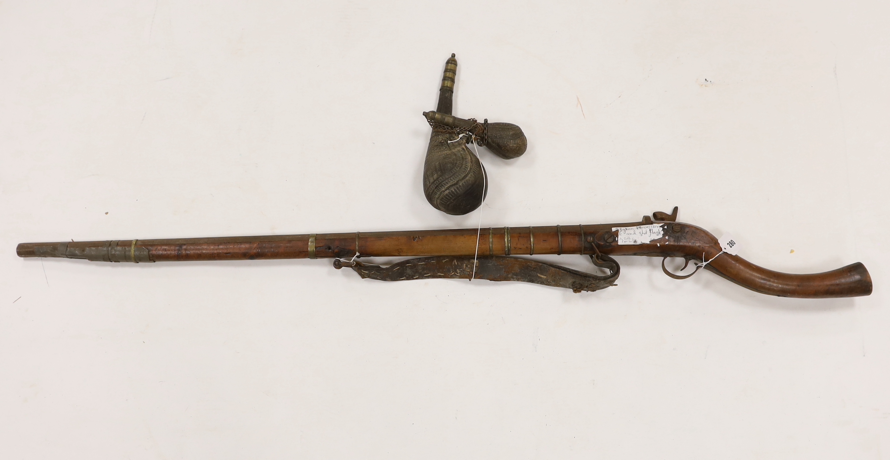 An Afghan percussion rifle with octagonal barrel and brass mounts, barrel 105.5cm, together with two leather powder flasks